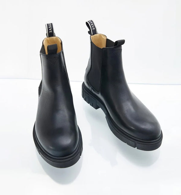 Cashville från Sneaky Steve är en stilren och mångsidig Chelsea boot med en modern silhuett. Tillverkad i ett robust, genuint läder som kommer att åldras med fin patina och med ett bekvämt foder i anilinläder. Gjord på deras egen sula i naturgummi, med Sneaky Steve-logotypen på hälen. Färg svart