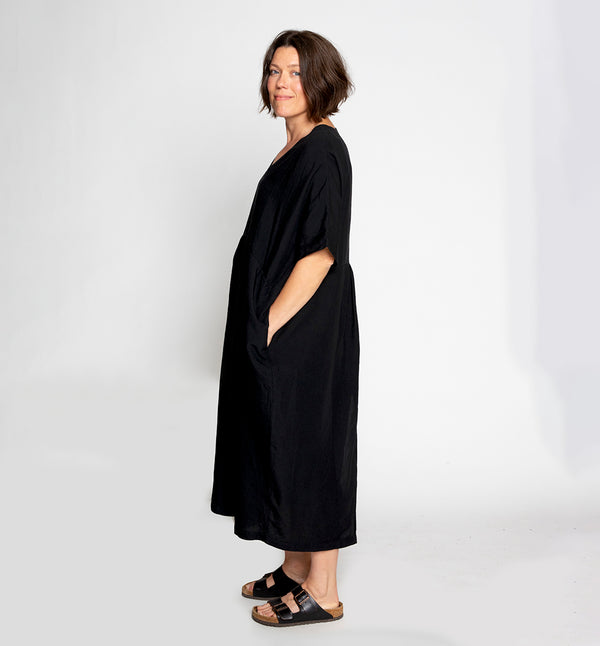 Klänning Eva från danska Muse Wear. V-ringad, skuren i midjan, fickor i sidorna och slits bak. Sydd i en lyxig Tencel- och linneblandning. Designad i danska Thy. 
Färg: Svart
Material:  70% Tencel, 30% linne. Detta tyg är tillverkat i Portugal.