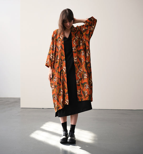 Lieblings kimono Gro i tyget Thalia. En lång lyxig kimono med fina kragdetaljer. Band att knyta i midjan. I kollektion Ridå har vi gjort Gro lite kortare än tidigare och i två storlekar. Tidigare onesize är nu S/M. 
Färg: Blommor i grönt, gult, brunt och vitt på orange botten.
Material: 51% EcoVero, 49% viskos från Frankrike.