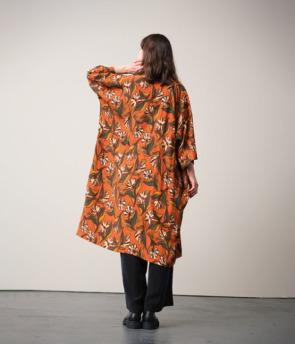 Lieblings kimono Gro i tyget Thalia. En lång lyxig kimono med fina kragdetaljer. Band att knyta i midjan. I kollektion Ridå har vi gjort Gro lite kortare än tidigare och i två storlekar. Tidigare onesize är nu S/M. 
Färg: Blommor i grönt, gult, brunt och vitt på orange botten.
Material: 51% EcoVero, 49% viskos från Frankrike.