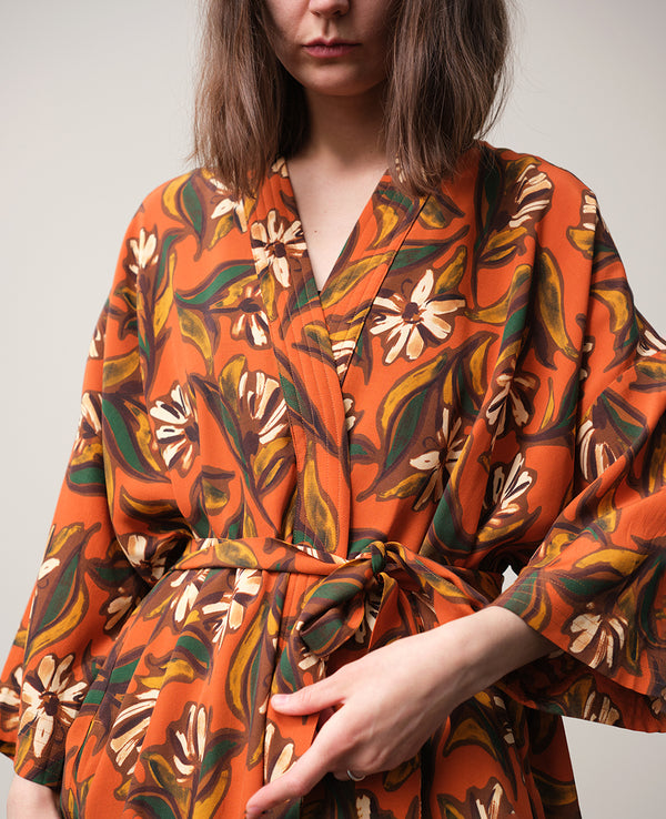Lieblings kimono Gro i tyget Thalia. En lång lyxig kimono med fina kragdetaljer. Band att knyta i midjan. I kollektion Ridå har vi gjort Gro lite kortare än tidigare och i två storlekar. Tidigare onesize är nu S/M. 
Färg: Blommor i grönt, gult, brunt och vitt på orange botten.
Material: 51% EcoVero, 49% viskos från Frankrike.