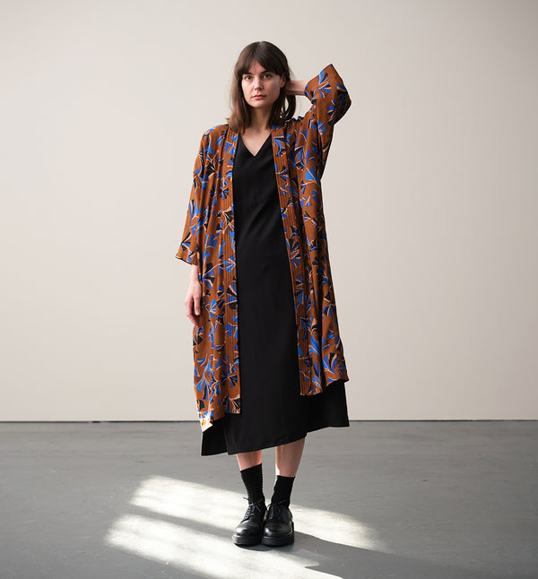 Lieblings kimono Gro i tyget Tosca. En lång lyxig kimono med fina kragdetaljer. Band att knyta i midjan. I kollektion Ridå har vi gjort Gro lite kortare än tidigare och i två storlekar. Tidigare onesize är nu S/M. 
Färg: Mönster i kornblått, svart och beige på nougatbrun botten.
Material: 51% EcoVero, 49% viskos från Frankrike.