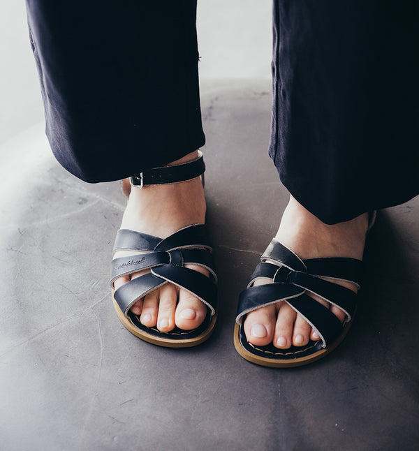 Svarta sandaler från det amerikanska märket Salt-Water Sandal. Modellen heter Original. Original har flätat läder över foten och knäpps med spänne över vristen. Svarta