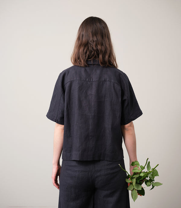 kortärmade skjorta Kino. Krage med slag, knappar fram, två små veck bak i ryggen och liten slits i sidorna. Sydd i ett stadigt linnetyg. Skjortan är förtvättad.
Färg: Kolgrå. Svarta knappar.
Material: 100% lin, förtvättat.