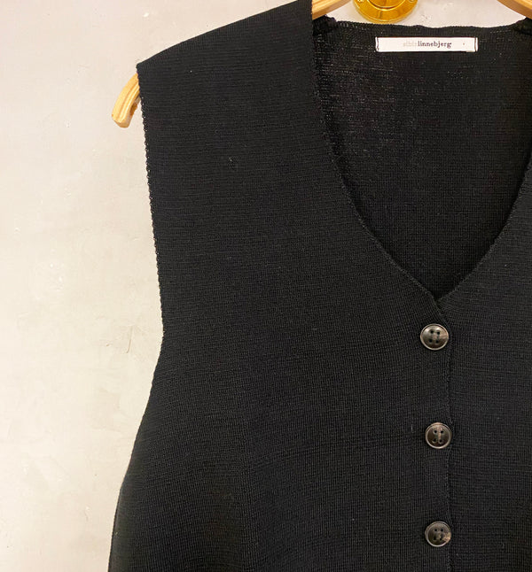 Väst Khloe från Sibin Linnebjerg. V-ringad väst med knappar fram. Styla den med en skjorta, långärmad eller bara bara armar.
Färg: Svart
Material: 50% merinoull, 50% akryl. Garnet kommer från Italien.