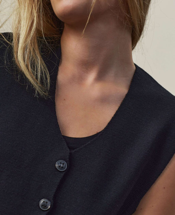 Väst Khloe från Sibin Linnebjerg. V-ringad väst med knappar fram. Styla den med en skjorta, långärmad eller bara bara armar.
Färg: Svart
Material: 50% merinoull, 50% akryl. Garnet kommer från Italien.
