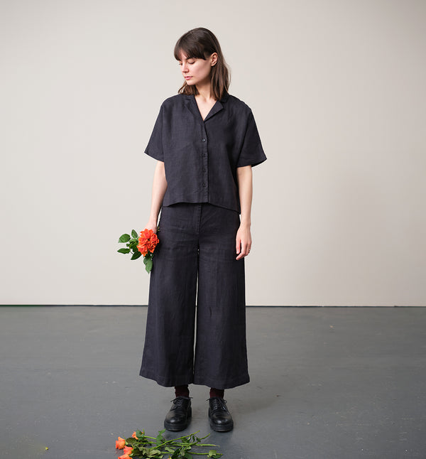 kortärmade skjorta Kino. Krage med slag, knappar fram, två små veck bak i ryggen och liten slits i sidorna. Sydd i ett stadigt linnetyg. Skjortan är förtvättad.
Färg: Kolgrå. Svarta knappar.
Material: 100% lin, förtvättat.