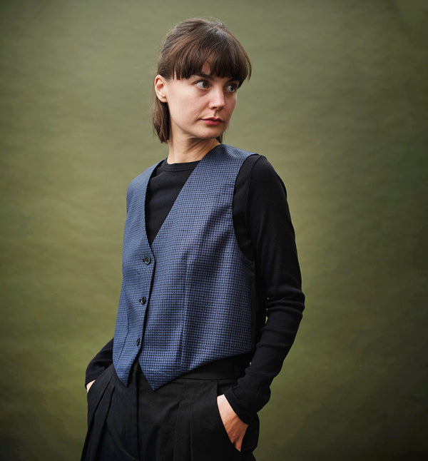 Liv är vår klassiska herrväst i damtappning. Liv Älv är sydd i ett smårutigt ull och polyestertyg. Svart foder och bakstycke.
Färg: Smårutig blå/svart. Svart foder.
Material: 55% polyester, 45% ull. Foder 100% viskos.
Materialursprung: Detta är resttyger från det svenska företaget Rekotex som jobbar med deadstocktyger, dvs överproduktion från textilindustrin runt om i Europa.  