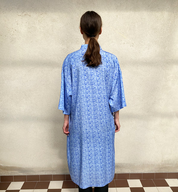 Vår kimonoklänning Mika i rak modell med omlottknyt och fickor i sidorna. Fin både som klänning och lång kimono.  Färg: Blå med våg- och bergmönster i mörkare blå. Material:  100% Lyocell
