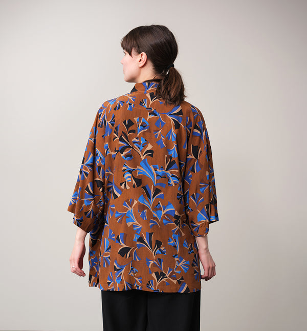 Jinbei kimono Miko! Med inspiration från japanska formspråket har vi designat en kimono som är avslappnat stylish. Knyts omlott och har en ficka fram. 
Färg: Mönster i kornblått, svart och beige på nougatbrun botten.
Material: 51% EcoVero, 49% viskos från Frankrike.