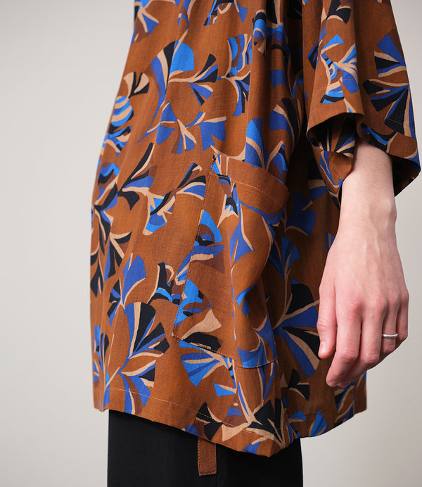 Jinbei kimono Miko! Med inspiration från japanska formspråket har vi designat en kimono som är avslappnat stylish. Knyts omlott och har en ficka fram. 
Färg: Mönster i kornblått, svart och beige på nougatbrun botten.
Material: 51% EcoVero, 49% viskos från Frankrike.