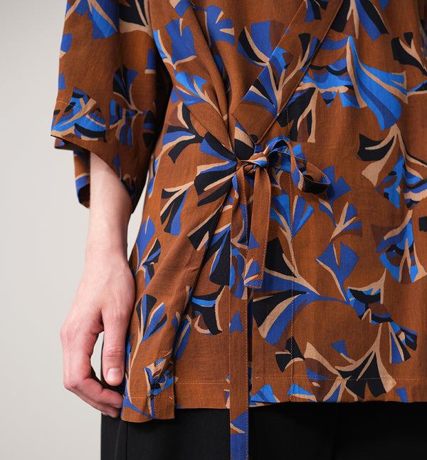 Jinbei kimono Miko! Med inspiration från japanska formspråket har vi designat en kimono som är avslappnat stylish. Knyts omlott och har en ficka fram. 
Färg: Mönster i kornblått, svart och beige på nougatbrun botten.
Material: 51% EcoVero, 49% viskos från Frankrike.