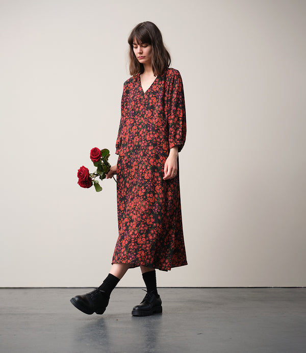 Vår klänning Nea! V-ringad, söm i midjan, trekvarts ärm med smal manschett och knapp, fickor i sidorna.  
Färg: Blommor i roströda, mörklila, gröna och orangea toner på svart botten.
Material: 51% EcoVero, 49% viskos från Frankrike.