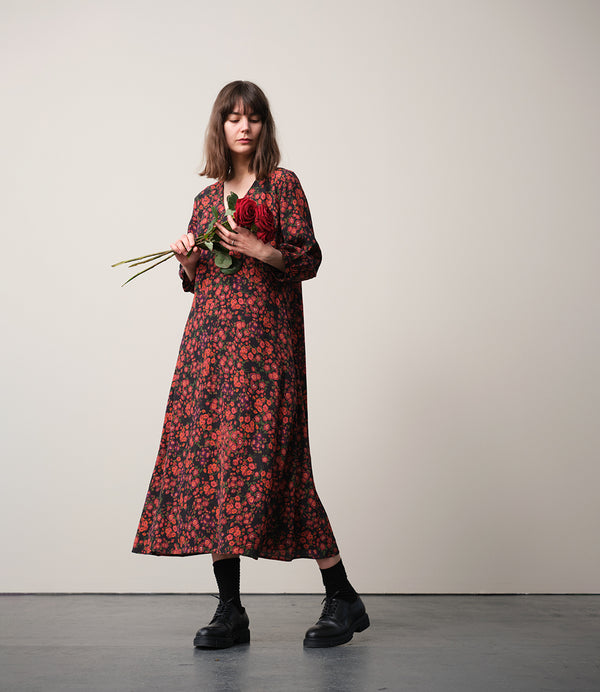 Vår klänning Nea! V-ringad, söm i midjan, trekvarts ärm med smal manschett och knapp, fickor i sidorna.  
Färg: Blommor i roströda, mörklila, gröna och orangea toner på svart botten.
Material: 51% EcoVero, 49% viskos från Frankrike.