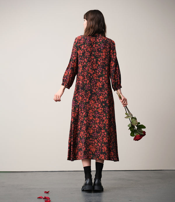 Vår klänning Nea! V-ringad, söm i midjan, trekvarts ärm med smal manschett och knapp, fickor i sidorna.  
Färg: Blommor i roströda, mörklila, gröna och orangea toner på svart botten.
Material: 51% EcoVero, 49% viskos från Frankrike.