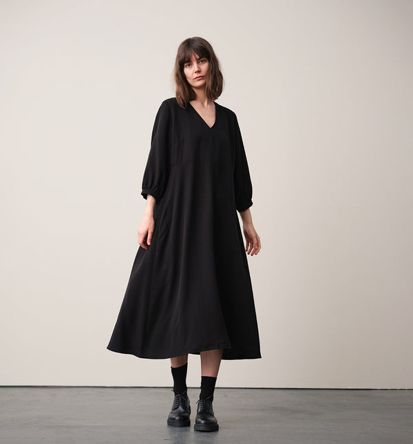 Vår klänning Nea! V-ringad, söm i midjan, trekvarts ärm med smal manschett och knapp, fickor i sidorna.  
Färg: Svart
Material: 100% Lyocell. Detta är ett deadstocktyg