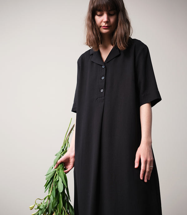 Vår klänning Sally! Sally är A-linjeformad med krage, knappslå, ok med små veck i ryggen och fickor i sidorna. Band att knyta i midjan. 
Färg: Svart
Material: 100% Lyocell. 