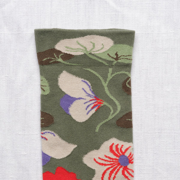 Strumpor 'Fleurs Cèdre' från franska Bonne Maison. De är tillverkade av finaste egyptiska bomull och en dubbeltrådig elastan. Som konstverk på fötterna! 
Färg: Blommor i beige, lila och rött på mörkgrön botten med ljuslila tå. 
Material: 90% bomull, 8% polyamid, 2% elastan