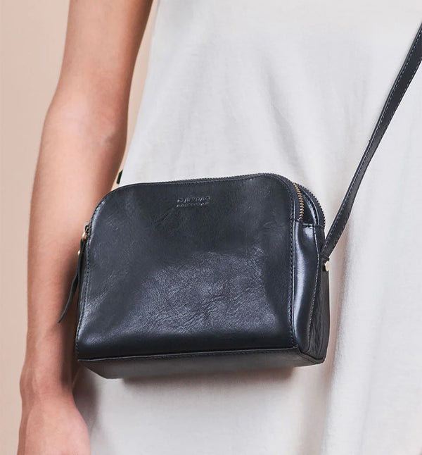 Svart Handväska Emily från märket O My Bag. Emily består av tre fack som gör den här väskan perfekt för dem som gillar att hålla ordning. Den har två stängda fack med blixtlås för alla dina värdesaker, och ett fack med magnetisk stängning. Justerbar axelrem i läder.