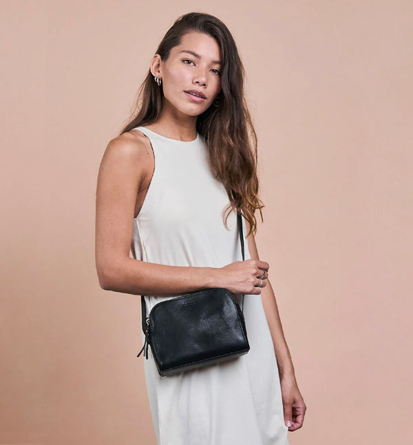 Svart Handväska Emily från märket O My Bag. Emily består av tre fack som gör den här väskan perfekt för dem som gillar att hålla ordning. Den har två stängda fack med blixtlås för alla dina värdesaker, och ett fack med magnetisk stängning. Justerbar axelrem i läder.