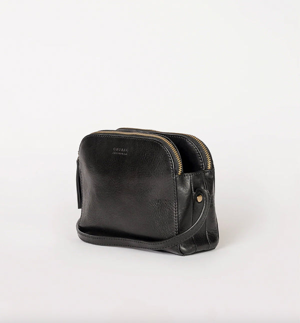 Svart Handväska Emily från märket O My Bag. Emily består av tre fack som gör den här väskan perfekt för dem som gillar att hålla ordning. Den har två stängda fack med blixtlås för alla dina värdesaker, och ett fack med magnetisk stängning. Justerbar axelrem i läder.