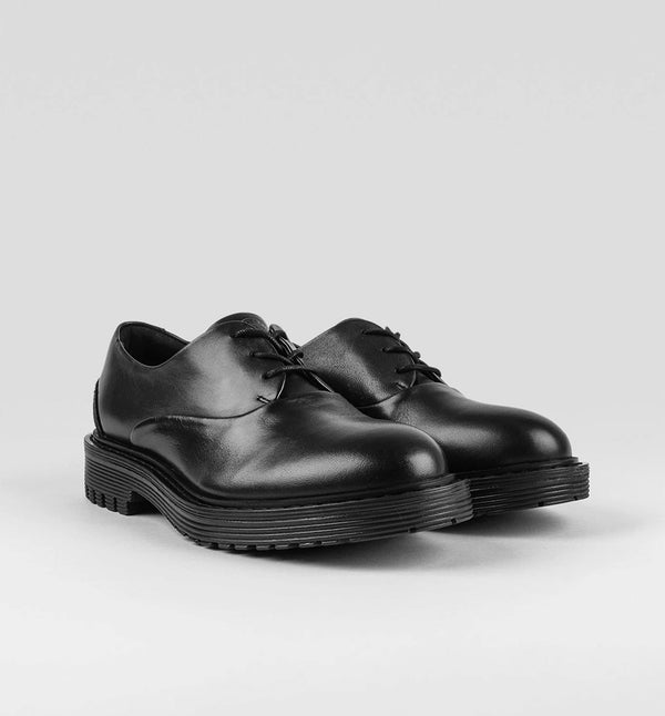 Ellis från märket Sneaky Steve är en lågt skuren sko med en grov sula. Ellis har en dressad look med ett Oxford snitt som ger den attityd. Svart.