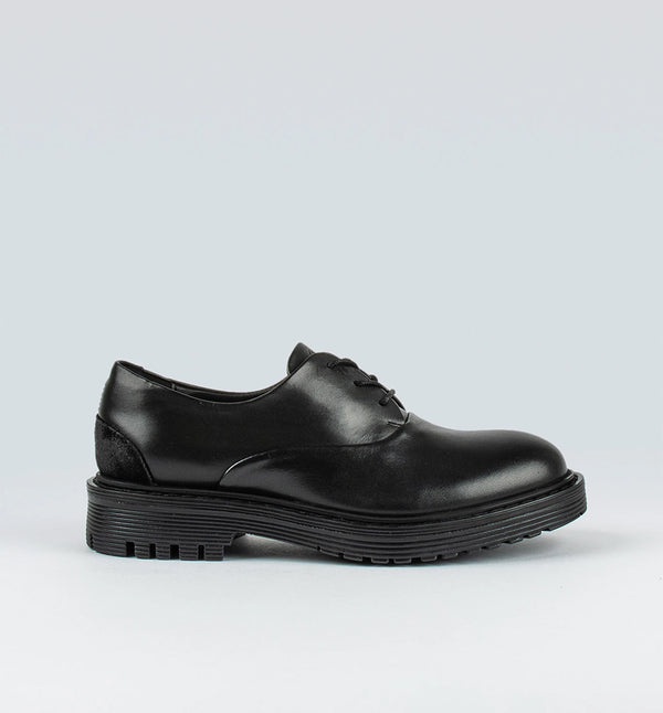 Ellis från märket Sneaky Steve är en lågt skuren sko med en grov sula. Ellis har en dressad look med ett Oxford snitt som ger den attityd. Svart.