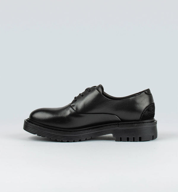 Ellis från märket Sneaky Steve är en lågt skuren sko med en grov sula. Ellis har en dressad look med ett Oxford snitt som ger den attityd. Svart.