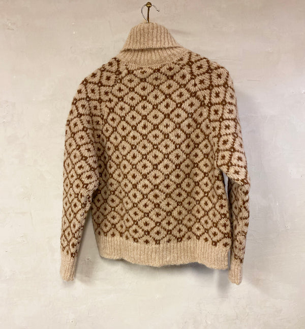 Polotröja Camelia från Sibin Linnebjerg. Stickad i en härlig alpackablandning med vackert mönster.&nbsp;

Färg: Sand / hasselbrun

Material: 85% i fin alpackaull, 15% polyamid. Certifierad mulesingfri ull. Garnet kommer från Italien.

Tillverkad i: Serbien&nbsp;

Tvätt: 30 grader ulltvätt