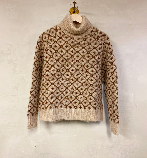 Polotröja Camelia från Sibin Linnebjerg. Stickad i en härlig alpackablandning med vackert mönster.&nbsp;

Färg: Sand / hasselbrun

Material: 85% i fin alpackaull, 15% polyamid. Certifierad mulesingfri ull. Garnet kommer från Italien.

Tillverkad i: Serbien&nbsp;

Tvätt: 30 grader ulltvätt