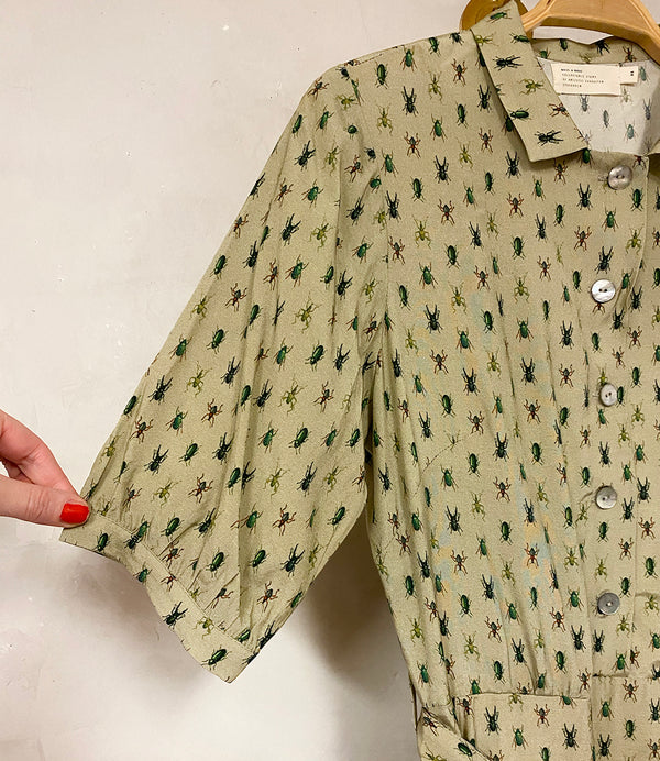 Klänning Arlom från Bric-a-brac! Krage, armbågslånga ärmar med smal manschett. Knappöppning till midjan. A-formad kjol med sneda sidofickor. Band i midjan. Pärlemorknappar.&nbsp;

Färg: Ljusgrön med skalbaggar i grönt, svart och rostrött

Material: 50% FSC EcoVero, 50% Rayon FSC EcoVero.

Skötselråd: 30 grader fintvätt. Strykes efter tvätt. 2% i längd.

Tillverkad i:&nbsp;Litauen