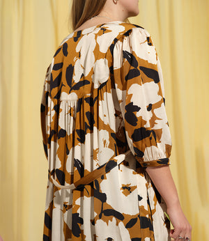 Liebling klänning Bonnie! Bonnie är en smula countryinspirerad i modellen. V-ringad, puffiga ärmar, fickor i sidorna och band att knyta i midjan. Rundat ok bak. Armbågslång ärm med smal manschett med en knapp. Svarta knappar mitt fram. Tyget är blankt vilket ger en lyxig känsla!&nbsp;

Färg: Vita blommor och svarta blad på guldbrun botten.&nbsp;

Material: 51% EcoVero, 49% viskos från Frankrike.