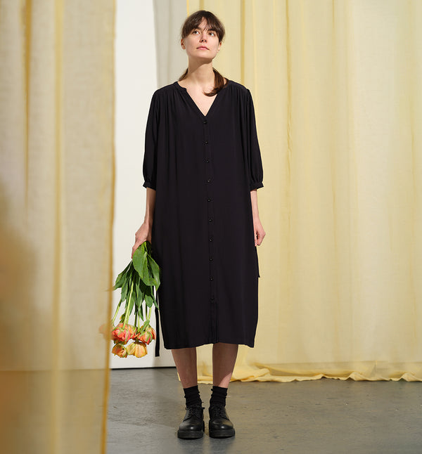  klänning Bonnie! Bonnie är en smula countryinspirerad i modellen. V-ringad, puffiga ärmar, fickor i sidorna och band att knyta i midjan. Rundat ok bak. Armbågslång ärm med smal manschett med en knapp. Svarta knappar mitt fram.&nbsp;

Färg: Riktigt mörkblå, nästan svart

Material: 100% viskos

Materialursprung:&nbsp;Detta tyg kommer från Italien.&nbsp;Deadstocktyg 