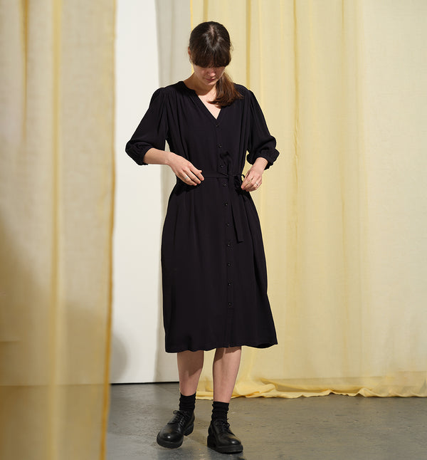  klänning Bonnie! Bonnie är en smula countryinspirerad i modellen. V-ringad, puffiga ärmar, fickor i sidorna och band att knyta i midjan. Rundat ok bak. Armbågslång ärm med smal manschett med en knapp. Svarta knappar mitt fram.&nbsp;

Färg: Riktigt mörkblå, nästan svart

Material: 100% viskos

Materialursprung:&nbsp;Detta tyg kommer från Italien.&nbsp;Deadstocktyg 