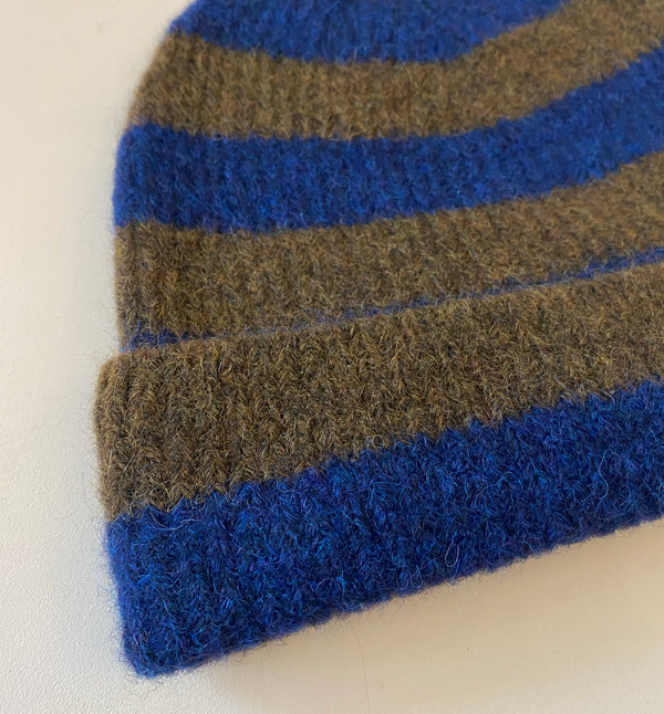 Stickad randig mössa i mjuk alpackablandning.&nbsp;

Färg: Brun/mörkblå

Material: 48% baby alpackaull, 20% ull, 30% polyamid, 2% elastan.

Tillverkad i: Serbien

Tvätt:&nbsp;30 grader fintvätt