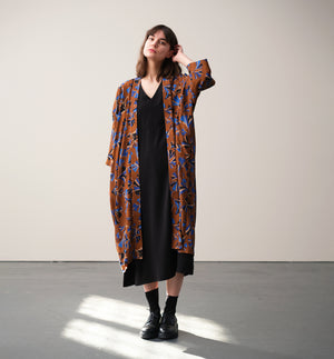 Lieblings kimono Gro i tyget Tosca. En lång lyxig kimono med fina kragdetaljer. Band att knyta i midjan. I kollektion Ridå har vi gjort Gro lite kortare än tidigare och i två storlekar. Tidigare onesize är nu S/M.&nbsp;

Färg: Mönster i kornblått, svart och beige på nougatbrun botten.

Material: 51% EcoVero, 49% viskos från Frankrike.