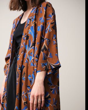 Lieblings kimono Gro i tyget Tosca. En lång lyxig kimono med fina kragdetaljer. Band att knyta i midjan. I kollektion Ridå har vi gjort Gro lite kortare än tidigare och i två storlekar. Tidigare onesize är nu S/M.&nbsp;

Färg: Mönster i kornblått, svart och beige på nougatbrun botten.

Material: 51% EcoVero, 49% viskos från Frankrike.