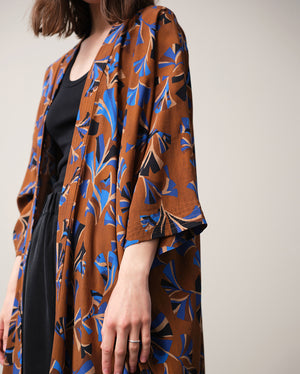 Lieblings kimono Gro i tyget Tosca. En lång lyxig kimono med fina kragdetaljer. Band att knyta i midjan. I kollektion Ridå har vi gjort Gro lite kortare än tidigare och i två storlekar. Tidigare onesize är nu S/M.&nbsp;

Färg: Mönster i kornblått, svart och beige på nougatbrun botten.

Material: 51% EcoVero, 49% viskos från Frankrike.