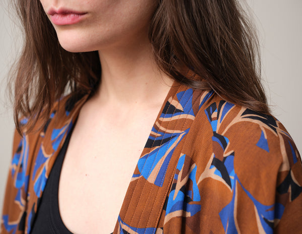 Lieblings kimono Gro i tyget Tosca. En lång lyxig kimono med fina kragdetaljer. Band att knyta i midjan. I kollektion Ridå har vi gjort Gro lite kortare än tidigare och i två storlekar. Tidigare onesize är nu S/M.&nbsp;

Färg: Mönster i kornblått, svart och beige på nougatbrun botten.

Material: 51% EcoVero, 49% viskos från Frankrike.