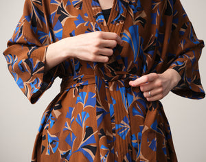 Lieblings kimono Gro i tyget Tosca. En lång lyxig kimono med fina kragdetaljer. Band att knyta i midjan. I kollektion Ridå har vi gjort Gro lite kortare än tidigare och i två storlekar. Tidigare onesize är nu S/M.&nbsp;

Färg: Mönster i kornblått, svart och beige på nougatbrun botten.

Material: 51% EcoVero, 49% viskos från Frankrike.