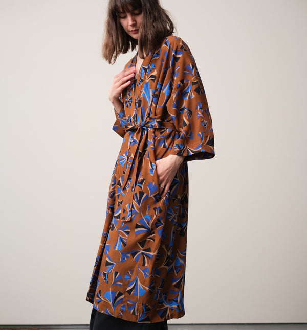 Lieblings kimono Gro i tyget Tosca. En lång lyxig kimono med fina kragdetaljer. Band att knyta i midjan. I kollektion Ridå har vi gjort Gro lite kortare än tidigare och i två storlekar. Tidigare onesize är nu S/M.&nbsp;

Färg: Mönster i kornblått, svart och beige på nougatbrun botten.

Material: 51% EcoVero, 49% viskos från Frankrike.