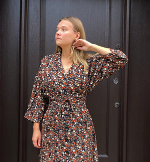 Klänningen Humla är en riktigt Lieblingfavorit. En ankellång kappklänning som kan bäras både öppen och stängd, som klänning eller kappa.&nbsp;Humla är en smula japaninspirerad i modellen och går att bära med eller utan det medföljande obi-bältet. Rak modell med krage, sprund bak och två fickor fram.&nbsp;

Färger: Små blommor i beige, vitt och orange på svart botten.

Material: 51% EcoVero, 49% viskos från Frankrike. 