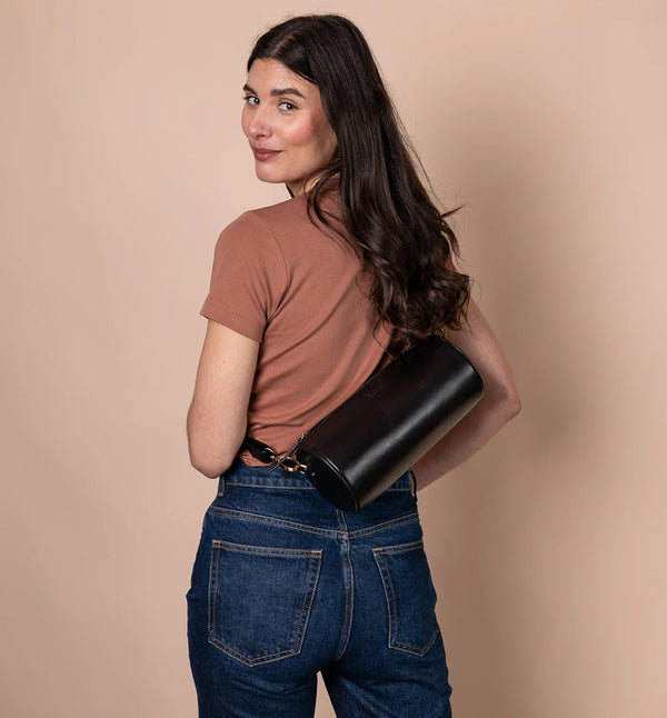 Handväska Izzy är O My Bag:s unika cylinderformade handväska som förkroppsligar den där edgy och retro, men ändå minimalistiska stilen. Denna cross-body-väska är tillverkad av hållbart ekologiskt läder. Izzys eleganta och moderna design gör att den passar lika bra till vardag som till fest. Den justerbara remmen gör att den kan bäras på olika sätt, som en cross-body-väska eller kortare för ett elegant axelalternativ. Svart läder. 