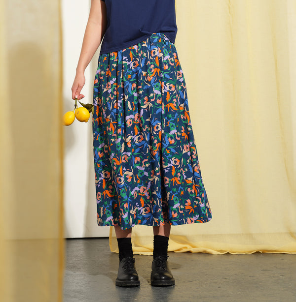 Kjolen Jojo! Avslappnad modell med veck fram, fickor i sidorna och resår med hällor i midjan. Sydd i en lyxig viskos med lite prickig struktur.&nbsp;

Färg: Blommor i orange, ljuslila, beige och klarblå på åskblå botten

Material: 51% EcoVero, 49% viskos från Frankrike.