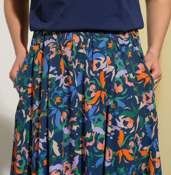 Kjolen Jojo! Avslappnad modell med veck fram, fickor i sidorna och resår med hällor i midjan. Sydd i en lyxig viskos med lite prickig struktur.&nbsp;

Färg: Blommor i orange, ljuslila, beige, grön och klarblå på åskblå botten

Material: 51% EcoVero, 49% viskos från Frankrike.