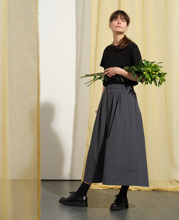 Kjolen Jojo! Avslappnad modell med veck fram, fickor i sidorna och resår med hällor i midjan. Styla med Jackie Milano!

Färg: Svart/vit rutig

Material: 98% bomull, 2% elastan&nbsp;

Materialursprung:&nbsp;Detta tyg är ett deadstock tyg och kommer från Portugal.&nbsp;