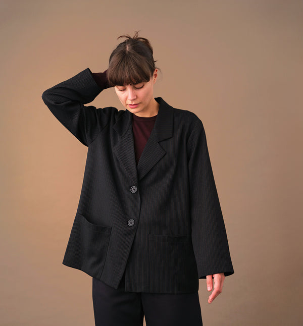 kavaj Sonia Kritstreck. En avslappnad kavaj. Helfodrad och fickor fram. Sydd i ett deadstock tyg.

Färg: Svart med grå och roströda streck, svart foder.

Material: Yttertyg: 100% ull, deadstock. Foder: 60% acetat, 40% viskos från Italien.