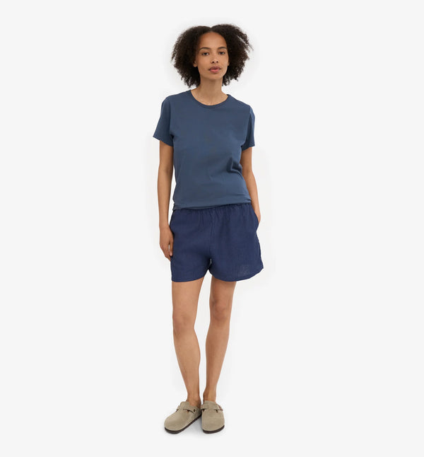 Linneshorts från Colorful standard. Dessa linneshorts är tillverkade av 100 % naturligt linne: lätta, luftiga och perfekta för varma dagar. De är enkla att bära, lätta att älska och passar till nästan allt. Resår i midjan och fickor i sidan. Förtvättad.

Färg:&nbsp;Marinblå med vita knappar.

Material: 100 % linne från Portugal

Certifierad med:&nbsp; Miljövänlig färg - Oeko-Tex®, PETA Approved Vegan

Tillverkad i: Portugal