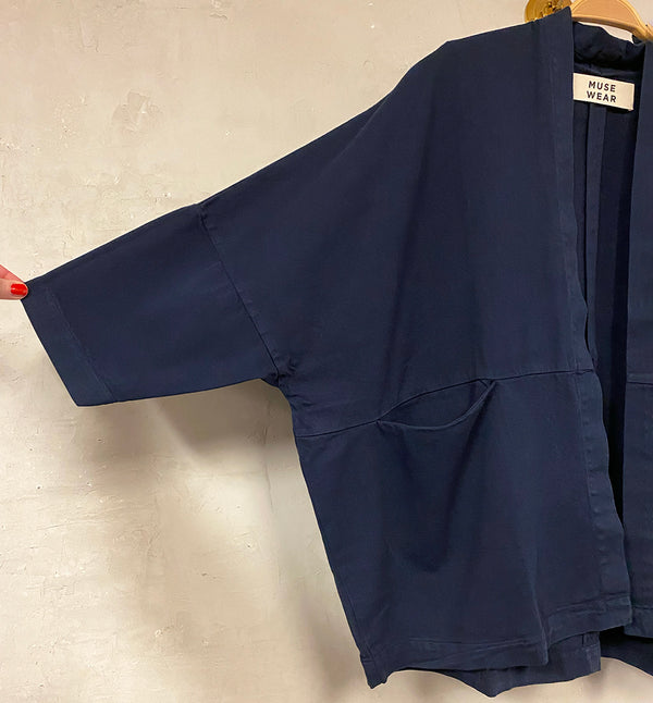 Kimono Livia från danska Muse Wear är en avslappnad kimonoinspirerad jacka med 3/4-ärmar. Fickor i söm mitt fram. Designad i danska Thy.&nbsp;

Färg: Mörkblå

Material: 50% ekologisk bomull, 50% återvunnen bomull

Skötselråd: 30 grader fintvätt

Tillverkad i: Portugal&nbsp;