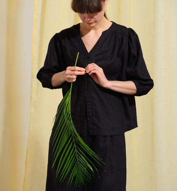 Liebling blus Lynn är en smula countryinspirerad i modellen. V-ringad, puffiga ärmar och rundat ok bak. Armbågslång ärm med smal manschett med en knapp. Svarta knappar mitt fram.

Färg: Svart

Material: 100% lin

Materialursprung:&nbsp;Detta tyg är ett deadstock tyg och kommer från Italien.&nbsp;